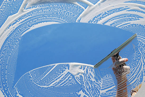 Window being washed with soap and a squeegee